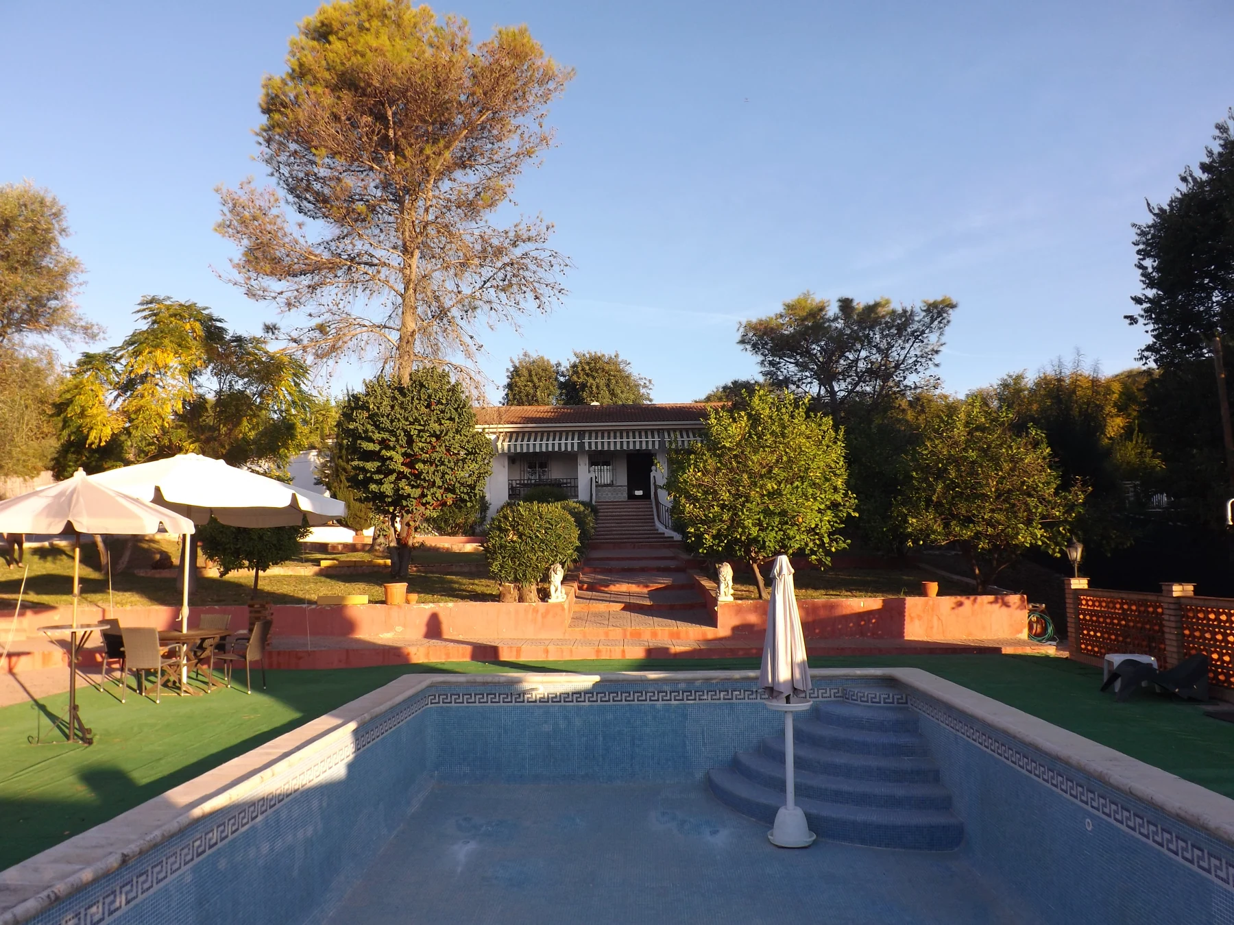 The swimming pool, terraces and garden looking towards the villa